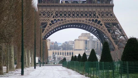 People passing by the Eiffel tower in Paris on a snowy day Stock Footage 317102703