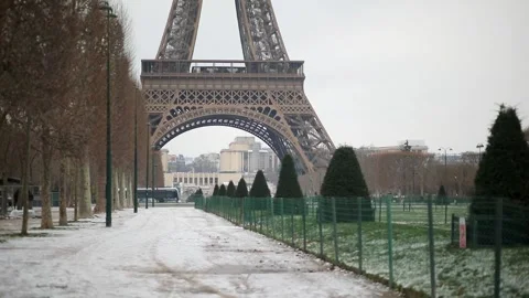 People passing by the Eiffel tower in Paris on a snowy day Stock Footage 317102720