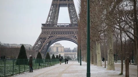 People passing by the Eiffel tower in Paris on a snowy day Stock Footage 317102732