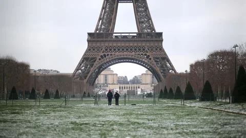 People passing by the Eiffel tower in Paris on a snowy day Stock Footage 317102750