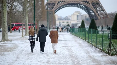 People passing by the Eiffel tower in Paris on a snowy day Stock Footage 317102803