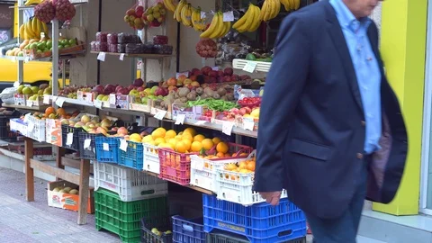 People passing in front of fruit and vegetable shop in Athens, Greece Stock Footage 97837273