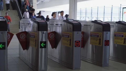 People passing LRT gate with token as ticket to use train services for travellin Stock Footage 105327710
