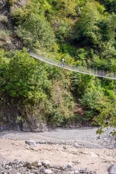 People passing over the hanging monkey bridge Foto stock
