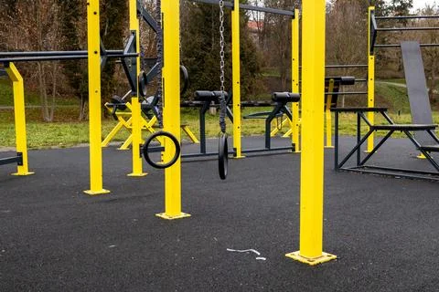 People perform various exercises using equipment at a bright yellow outdoor.. 스톡 사진