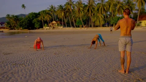 People performing yoga on beach during sunset Stock-Footage 75290144