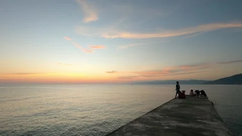 People on Pier at Sunset by Ocean Stock Footage 311962601