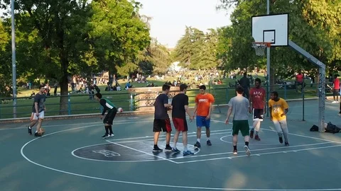 People playing basketball at city park Stock Footage