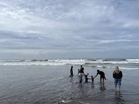 People playing on the beach with panoramic view of the sea Stock Photos