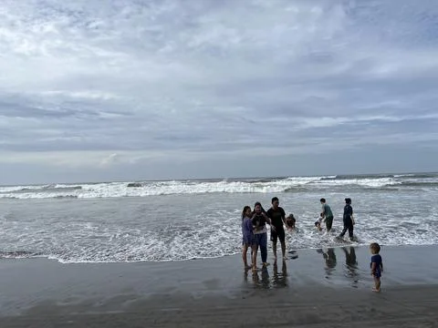 People playing on the beach with panoramic view of the sea Stock Photos