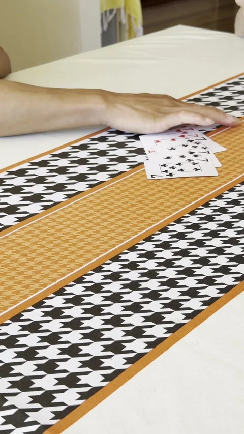 People playing cards on table with patterned runner Stock Footage 331178953