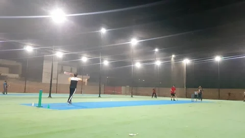 People playing cricket in cage covered with net at night. Stock Footage 346105295