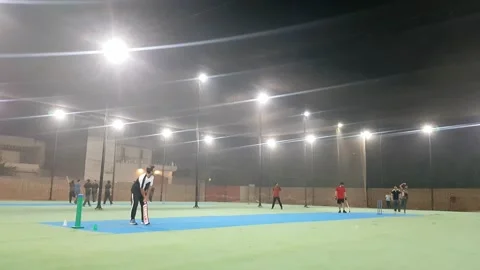 People playing cricket in cage covered with net at night. Stock Footage 346105460