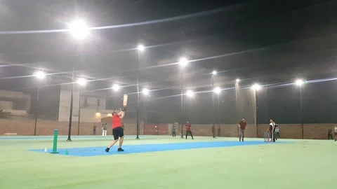People playing cricket in cage covered with net at night. Stock Footage 346105564