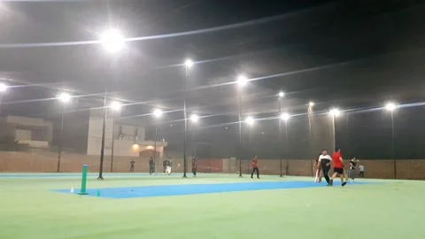 People playing cricket in cage covered with net at night. Stock Footage 346105660