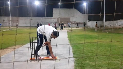 People playing cricket in cage covered with net at night. Stock Footage 346106011