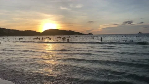 People Playing in the Ocean During the Sunset. Video stock 129398633
