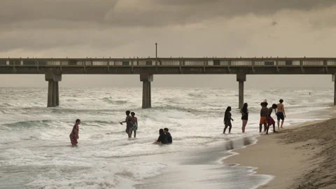 People Playing in the Ocean in Front of Deerfield Beach Pier Stock Footage 283412839