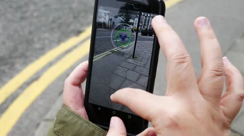 People playing "Pokemon GO" the hit augmented reality smart phone app Stock Footage