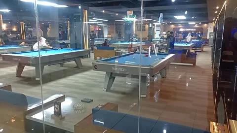 People playing pool table game inside a modern shopping mall billiard arena Stock Footage 332176455