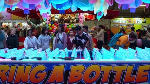 People playing ring a bottle game, a popular carnival game. Vidéo 312623532