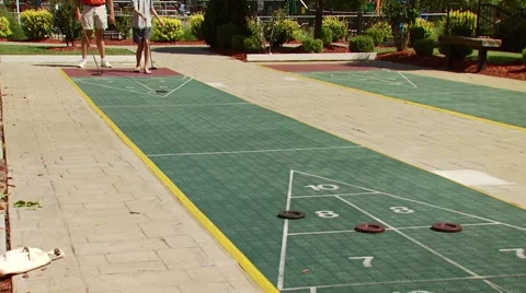 People playing shuffleboard outside on sunny day Stock Footage 54592853