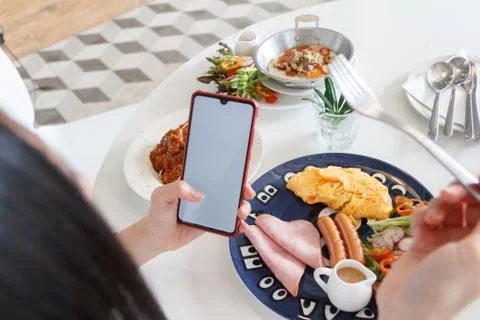 People playing smartphone while eating breakfast. white space for add text. Stock Photos