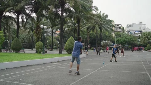 People playing squash racket sport in a public urban green park of Ho Chi Minh Stock Footage 325717641