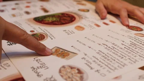 People Pointing at Menu Items While Ordering Food in Restaurant Stock Footage 345099866
