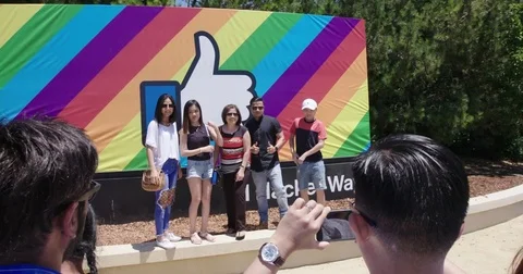 People posing in front of the facebook logo at Facebook headquarters, Silicon Stock Footage 77410244