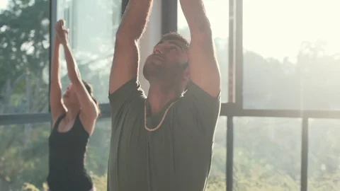 People practice warrior yoga pose in studio high key shot rapid slow motion Stock Footage 89593933