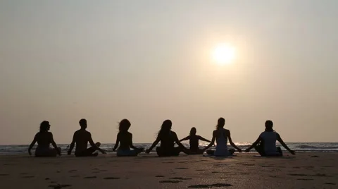 People practicing yoga at a sandy beach in Goa at sunset. Stock Footage 49592690