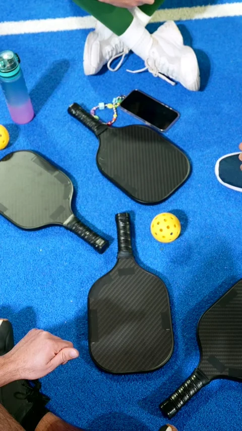People preparing to play pickleball on blue court Stock Footage 329549696