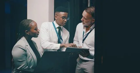 People, programming or tablet in server room, conversation or teamwork with Stock Photos