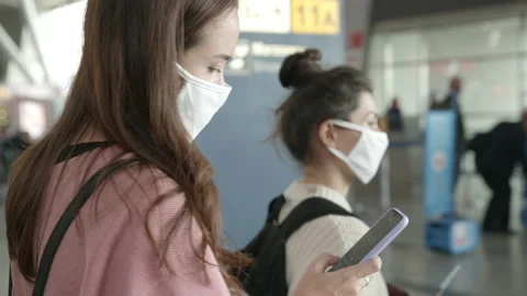 People in protective mask staying in a queue for boarding on plane. Two women in Stock Footage 141206861