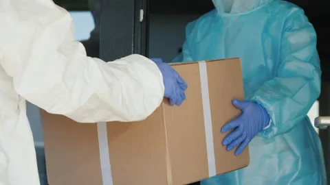 People in protective suits unload boxes of medicine Stock Footage 161399482