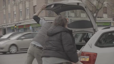 People putting items in the trunk of a car in Madrid, Spain Video stock 345027544