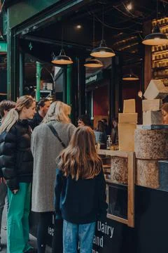 People queue at a cheese kiosk inside Borough Market in London, UK. Stock-Fotos