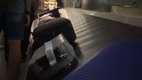 People queue at conveyor belt with luggage in airport building Video stock 148984279