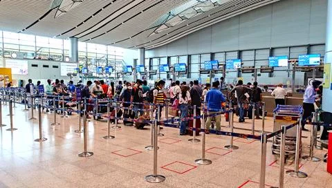 People queue lining up at check in counter in IGI Airport Foto stock