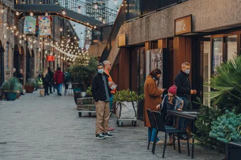 People queue outside a cafe in Coal Drops Yard, London, UK. Stock Photos