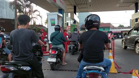 People queue at Pertamina to refuel their motorbikes Video stock 282252415