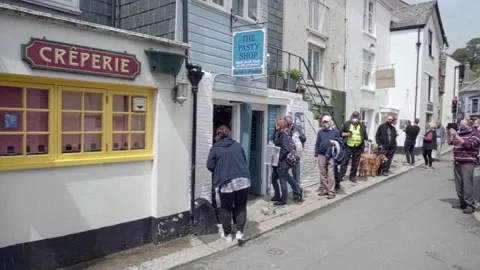 People Queuing Outside Bakers With Covid Masks On Stockbeeldmateriaal 154809757
