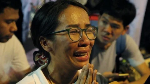 People react during prayers for Thai King Bhumibol Adulyadej's health at Siriraj Video stock 71502984