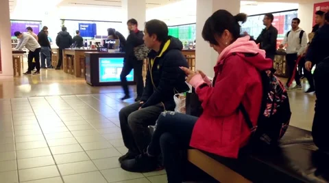People reading moblie message at rest area beside Microsoft store Video stock 49282865
