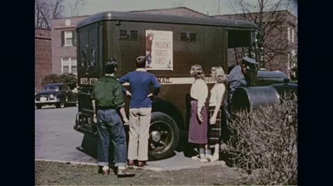 People reading poster of little Smokey on mail truck Stock Footage