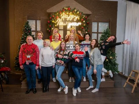 People in red sweater with deer posing in studio with Christmas decor Stock Photos