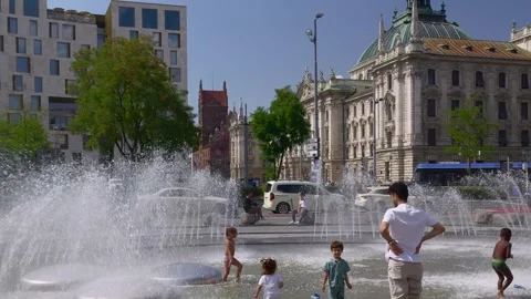 People refresh themselves at the Stachusbrunnen in Munich Stock Footage 342340666