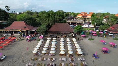 People Relax On Sandy Double Six Beach Under Rental Umbrellas in Seminyak, Stock Footage 247325711