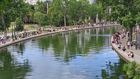 People Relaxing Along the Tree-Lined Canal Saint-Martin on a Sunny Day in Paris Stock-Footage 342320018